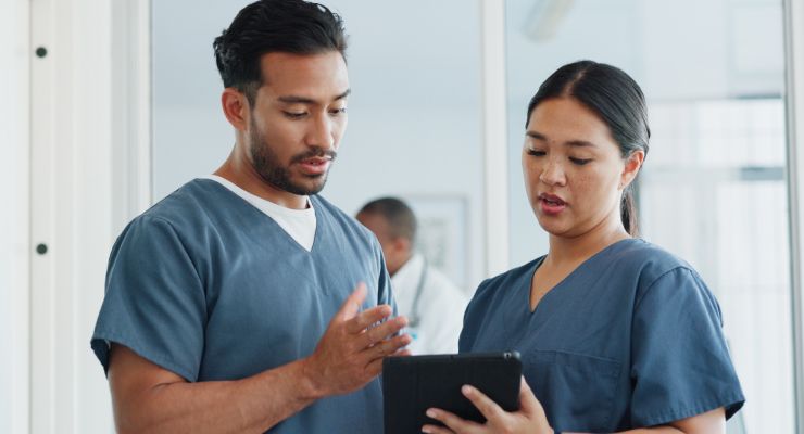 Image of a doctor and a nurse looking at a digital tablet